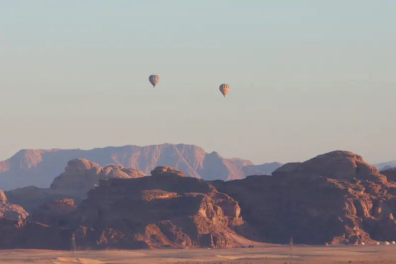 Two hot-air balloons over the Wadi Rum mountains at sunrise